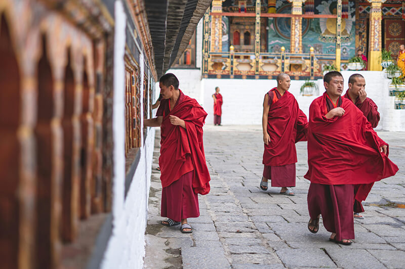 Bhutanese monks move through ancient monasteries