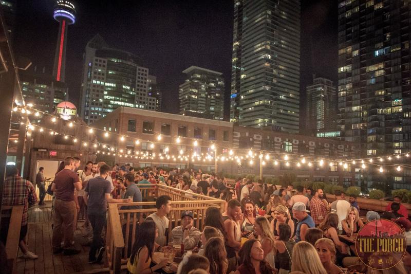 Young people party on a deck with city views of Toronto