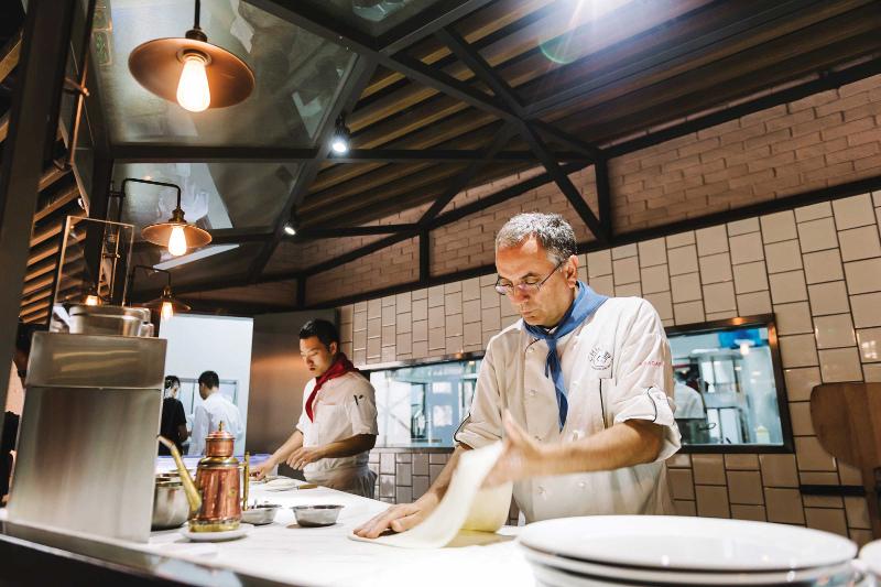 A man making a pizza in a kitchen